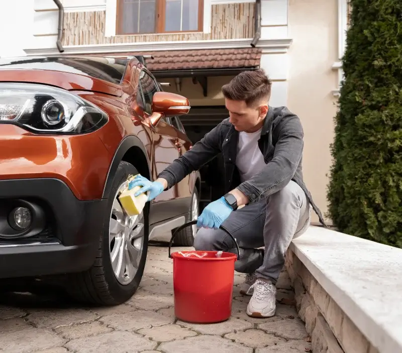 Lavage auto à domicile Flins-sur-Seine : professionnel intervenant sur un véhicule